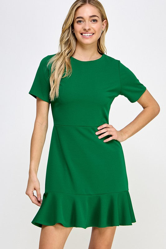 a long haired blonde model, hand on hip, shows us the fluted hem dress