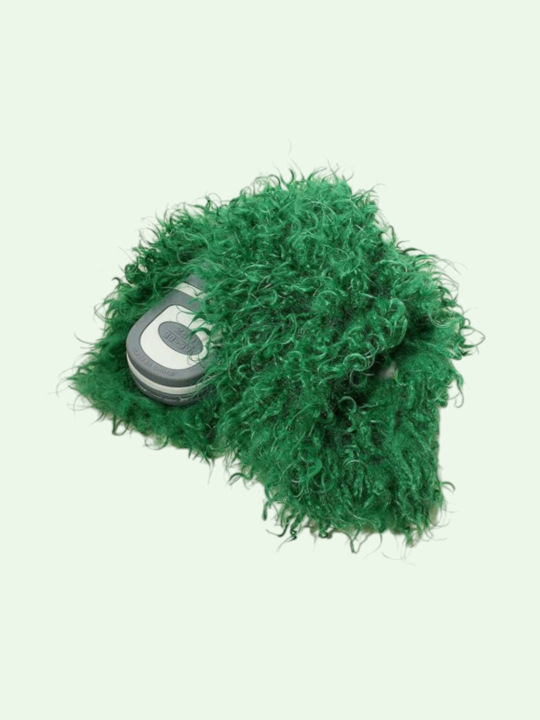 Green fuzzy slippers showing the solid bottom on a light green background