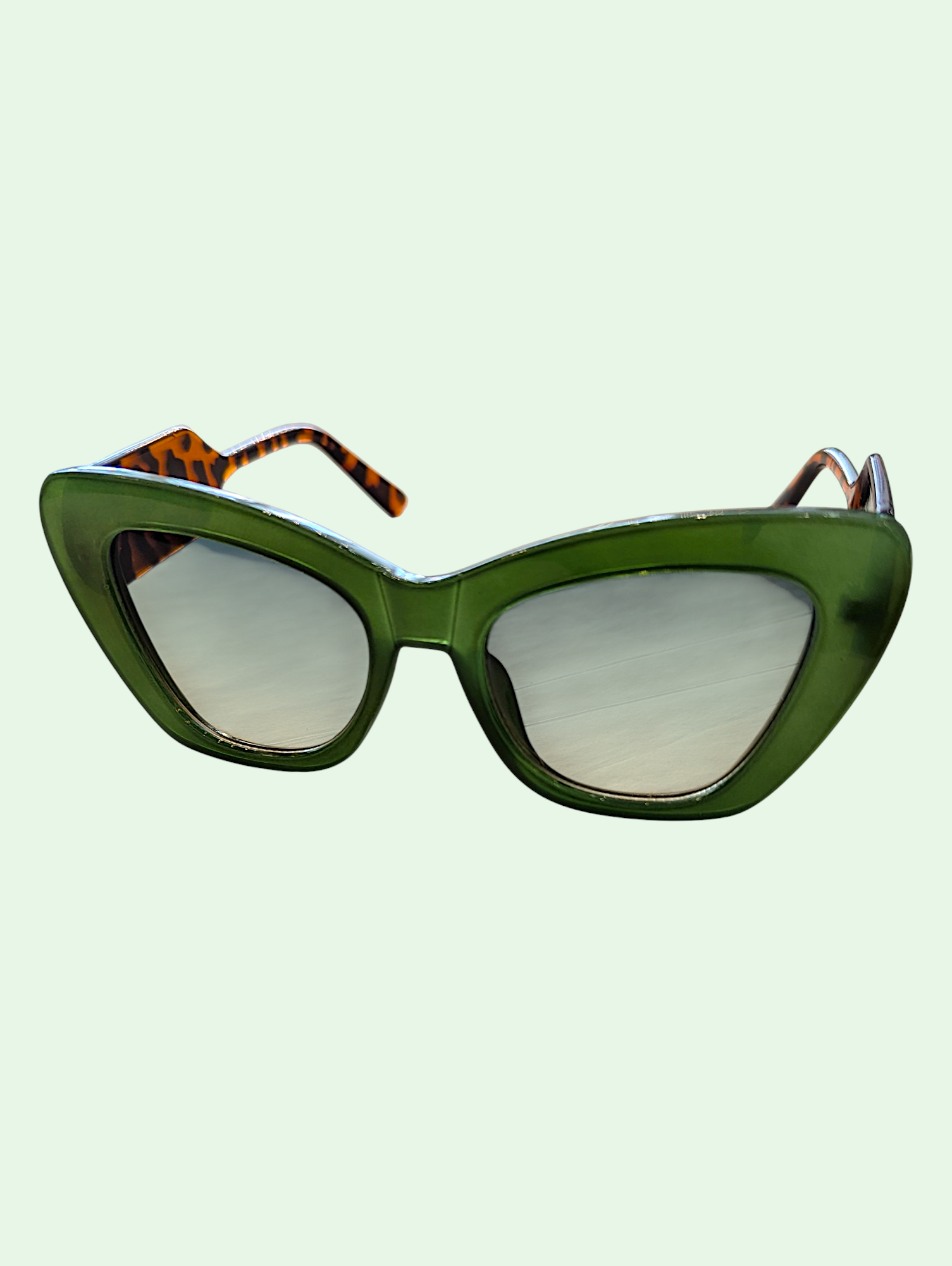 Green cat-eye sunglasses with a light green background