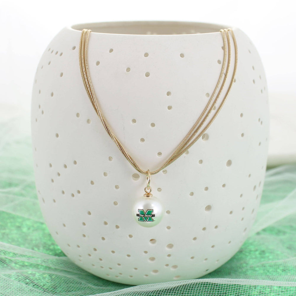 Necklace with a pendant on a white ceramic holder with gold accents