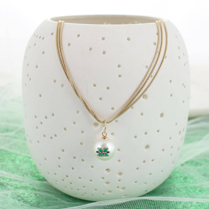 Necklace with a pendant on a white ceramic holder with gold accents