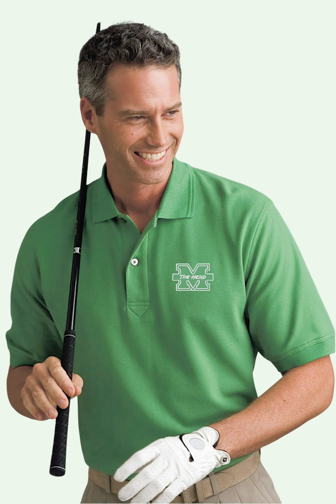 Man wearing a green polo shirt with a logo, holding a golf club on a white background