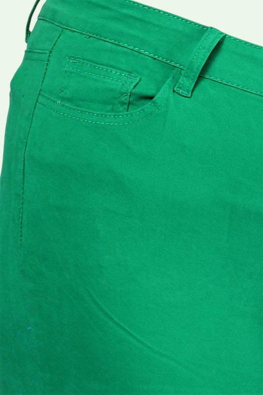 Close-up of green pants with a pocket detail on a light green background