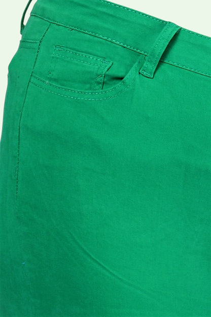 Close-up of green pants with a pocket detail on a light green background