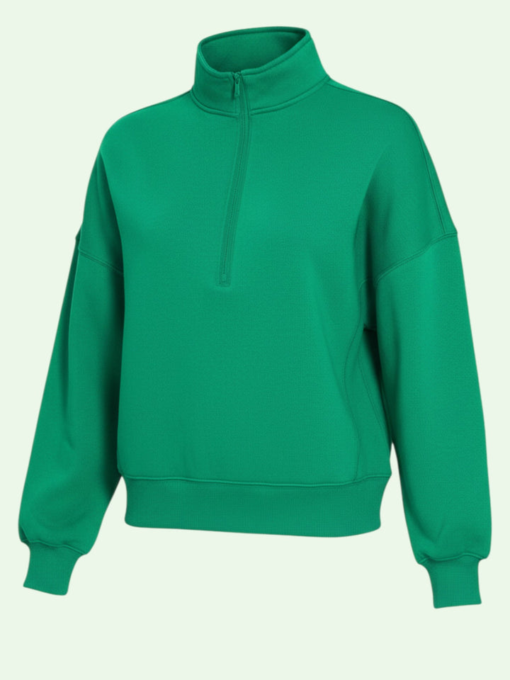 Green sweatshirt with a half zip on a light green background
