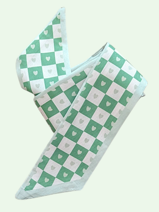  green and white checkered scarf with heart patterns on a light gray background