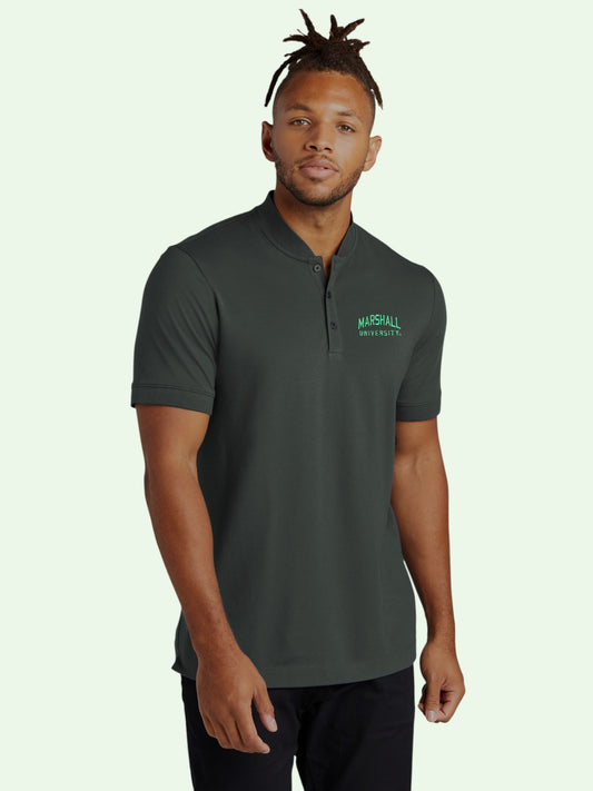 Man wearing a dark green polo shirt with a logo on a light green background