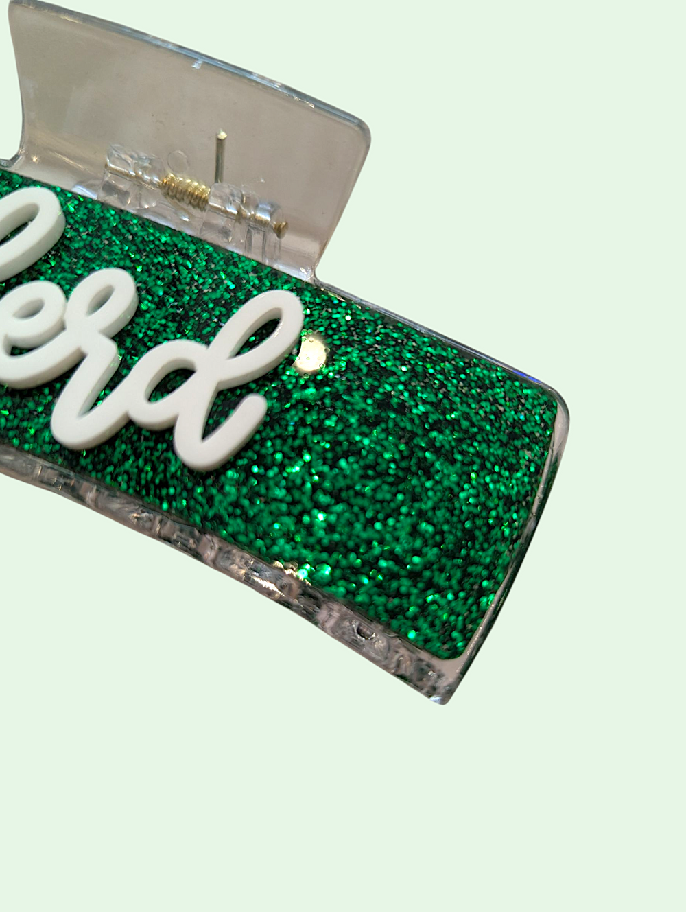 Green glittery product with 'herd' branding on a light green background