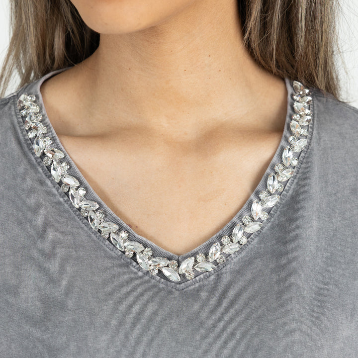 Gray top with crystal embellishments on a plain background