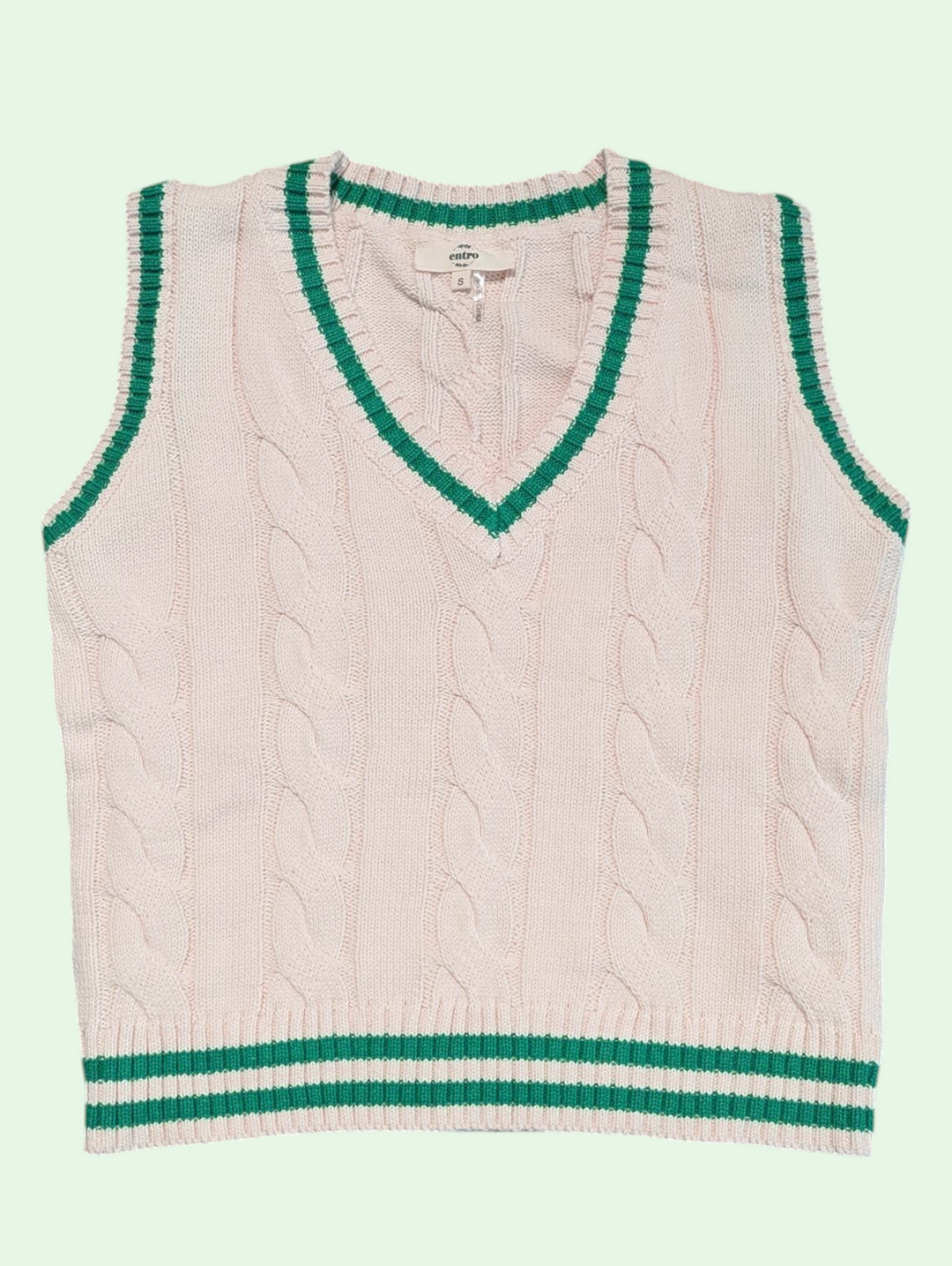 cream sweater vest with green trim on a light green background