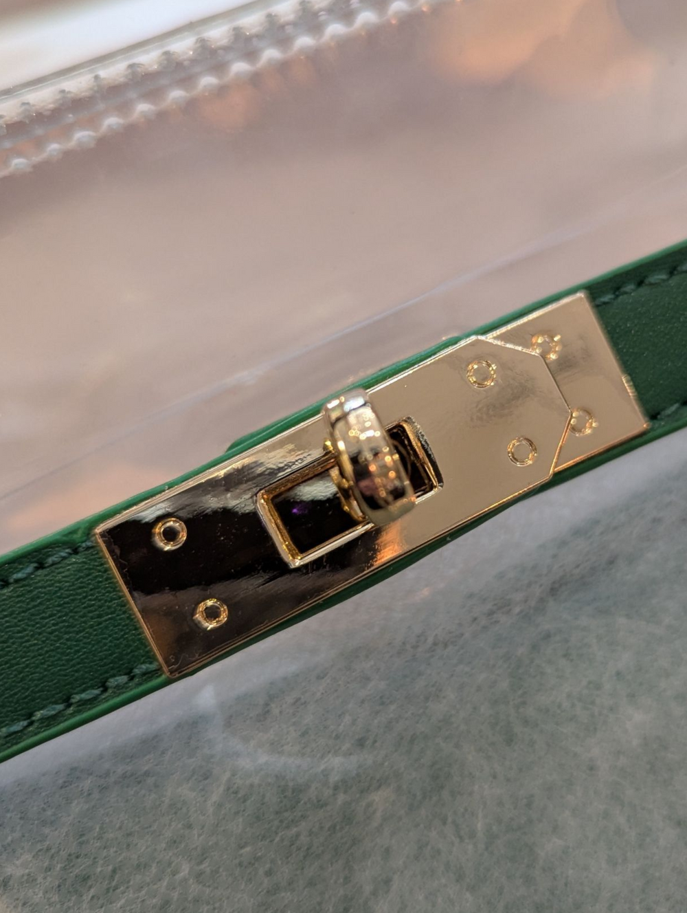 Green belt with gold buckle on a reflective surface