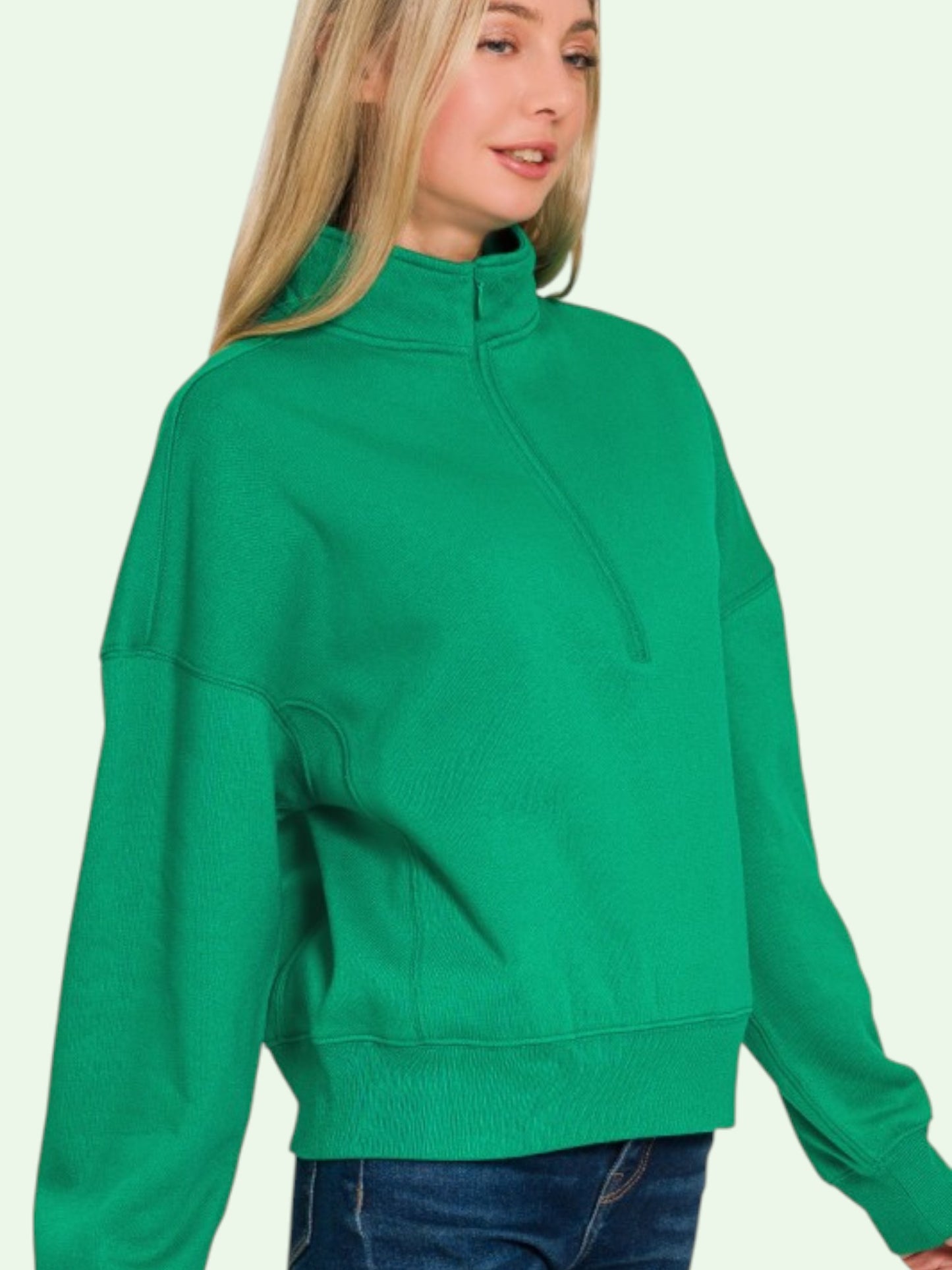Person wearing a green sweatshirt against a light background