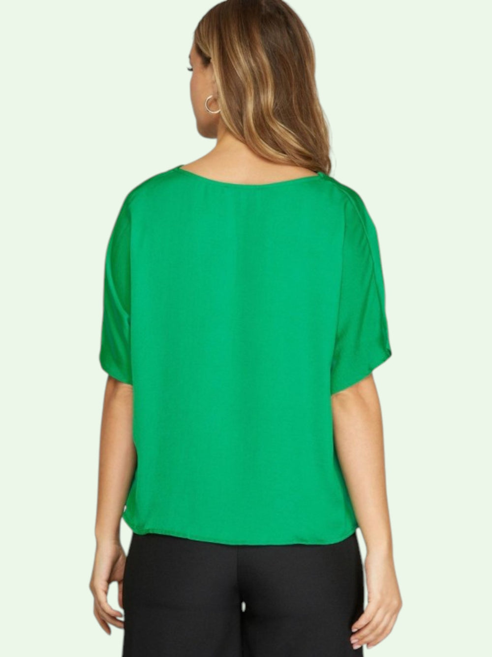 Woman wearing a green blouse with a plain background