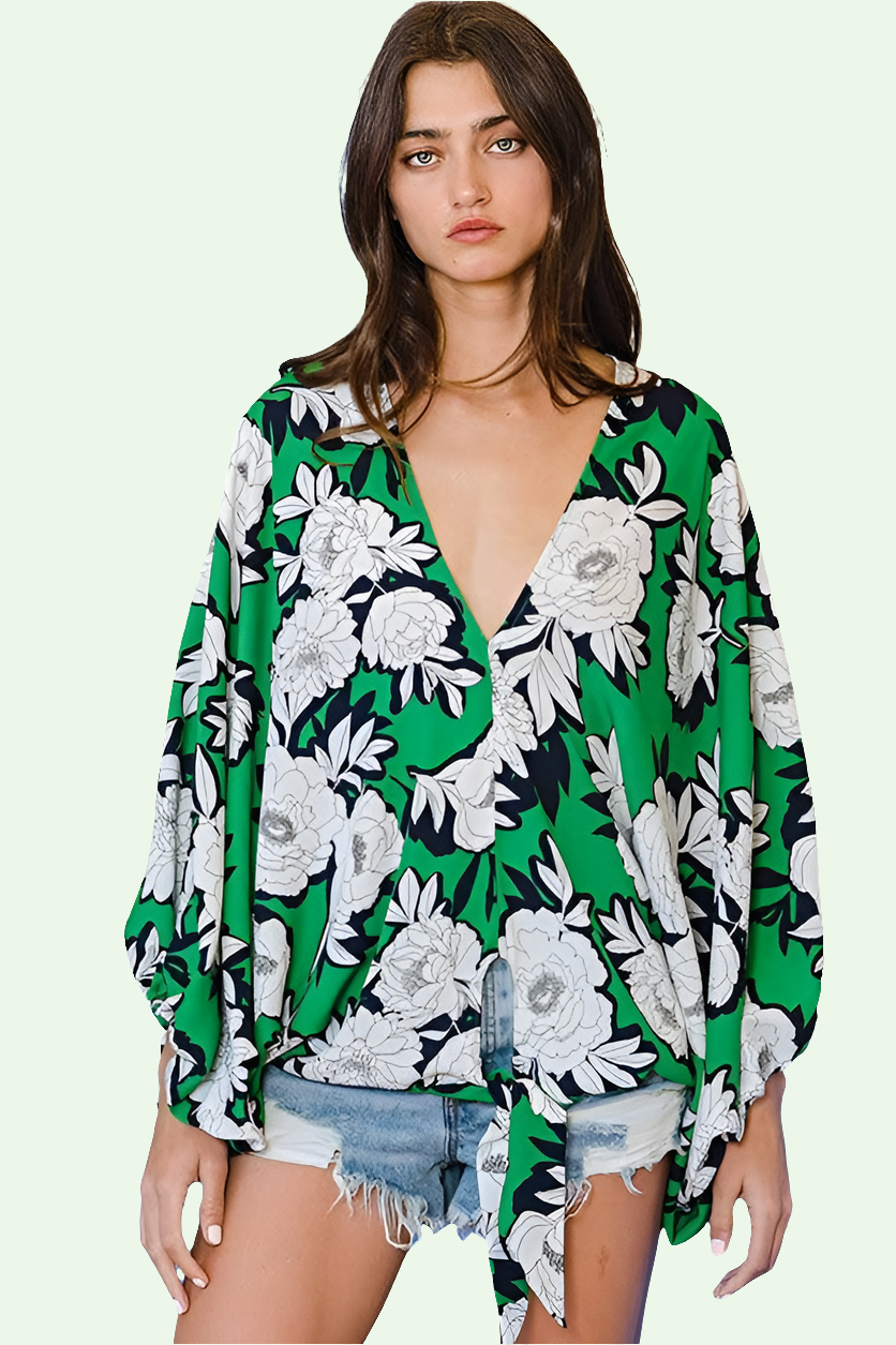 front view of  a Woman wearing a green floral kimono-style top on a light green background