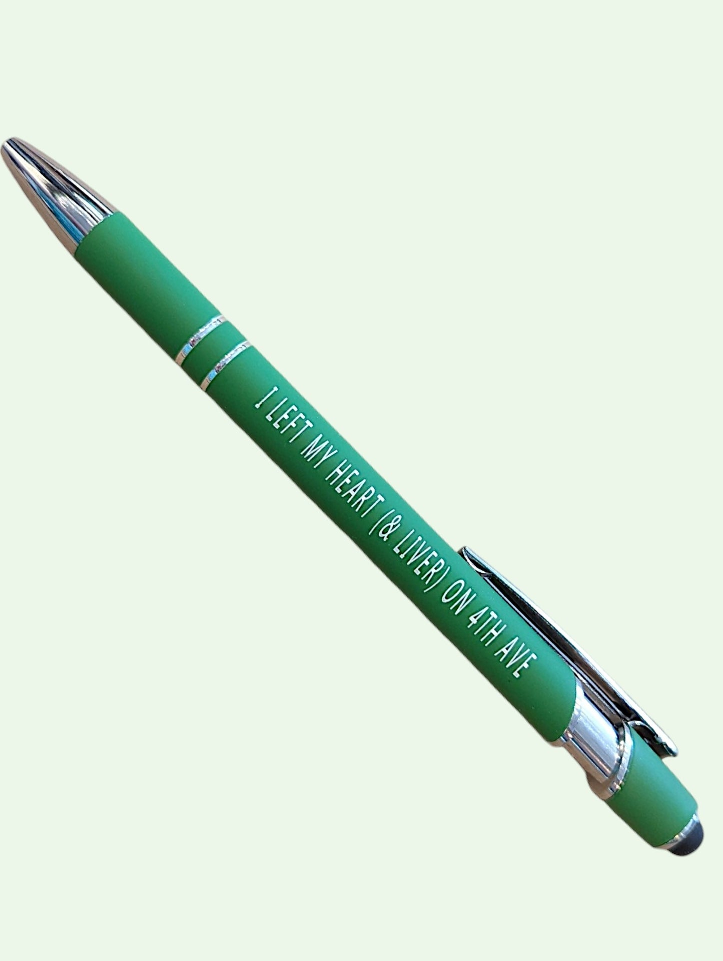 A green ballpoint pen with silver accents and white text that reads 'I LEFT MY HEART & LIVER ON ATLANTA', shown diagonally on a pale green background.