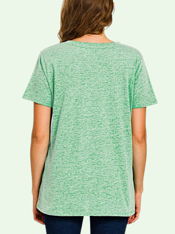 Person wearing a green t-shirt on a plain background, showing us the  back of the tee