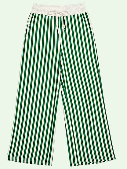 Green and white vertically striped wide-leg pants with a white elastic waistband and drawstring, shown against a pale mint green background.