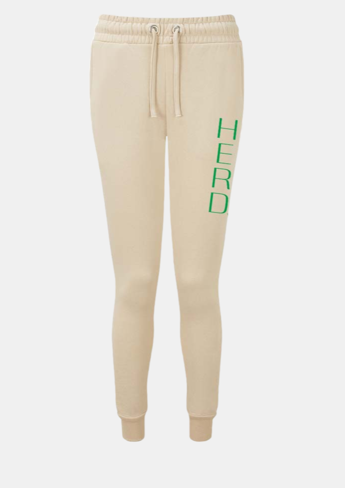 nude color jogger pants with HERD in large block letters down the left leg