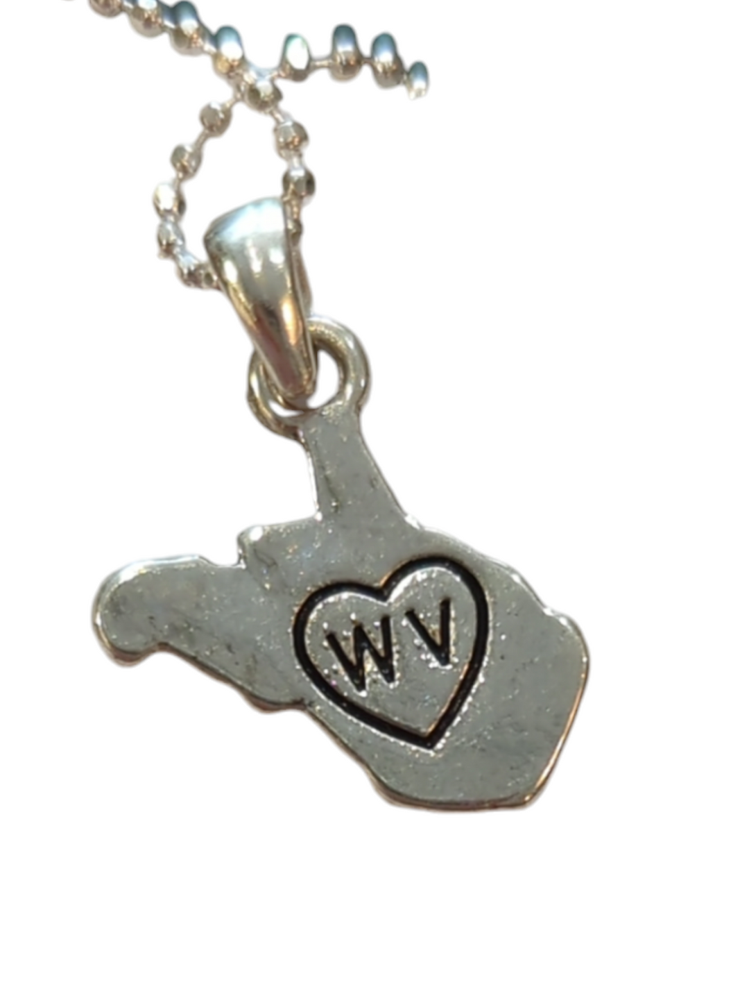 the rear detail view of the  WV charm showing it is stamped with a heart and the letters WV