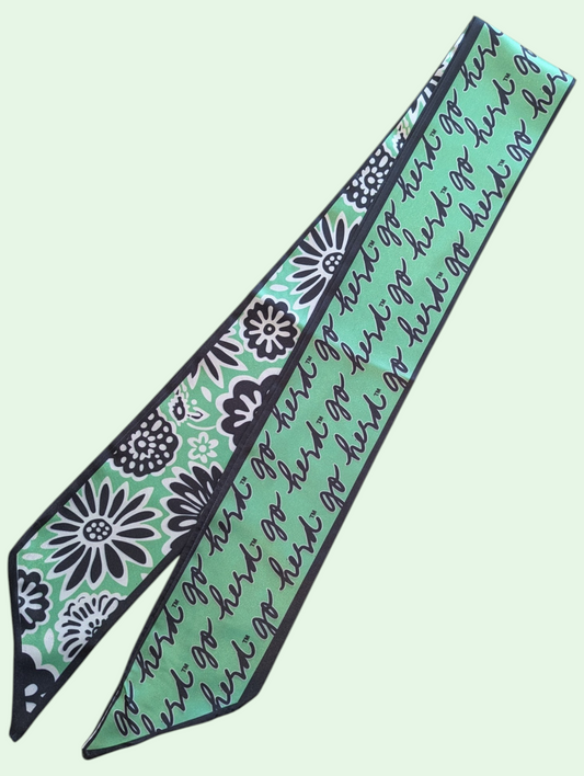 Green ribbon scarf with floral patterns and text on a light green background