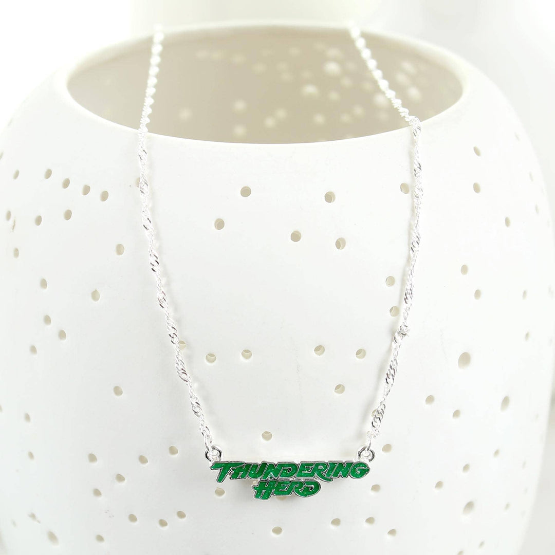 Necklace with 'Thundering Hero' pendant on a white polka dot shirt