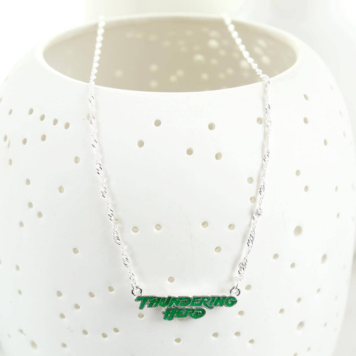 Necklace with 'Thundering Hero' pendant on a white polka dot shirt