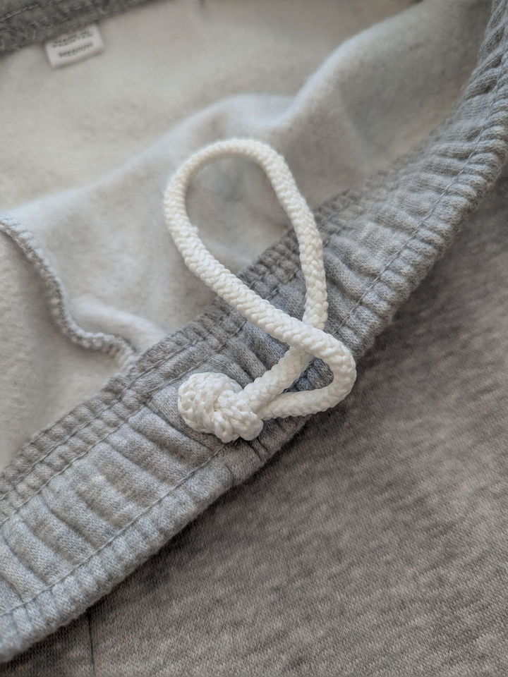Close-up of a textured fabric with a white cord and knot detail.