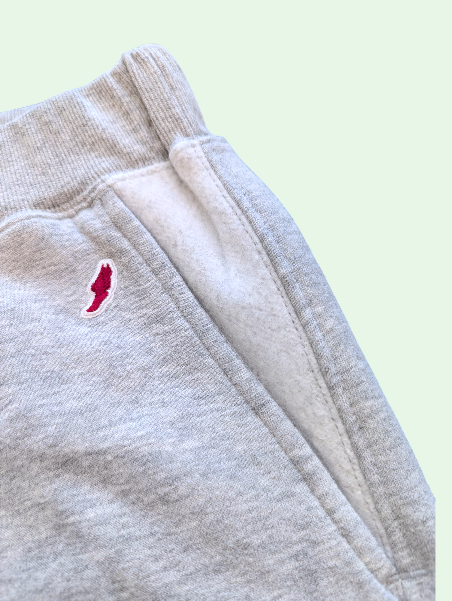 Close-up of a gray sweatpants showing the reverse detail on the pocket 