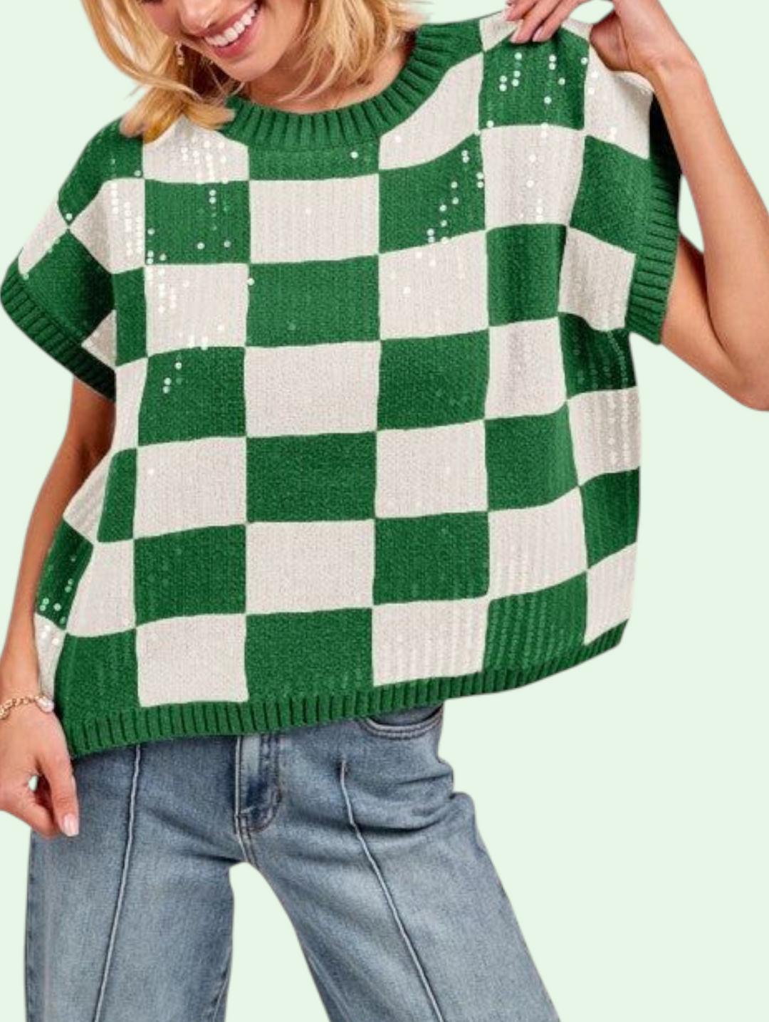 Person wearing a green and white checkered sweater with a plain background