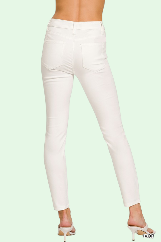 White pants on a model against a light green background