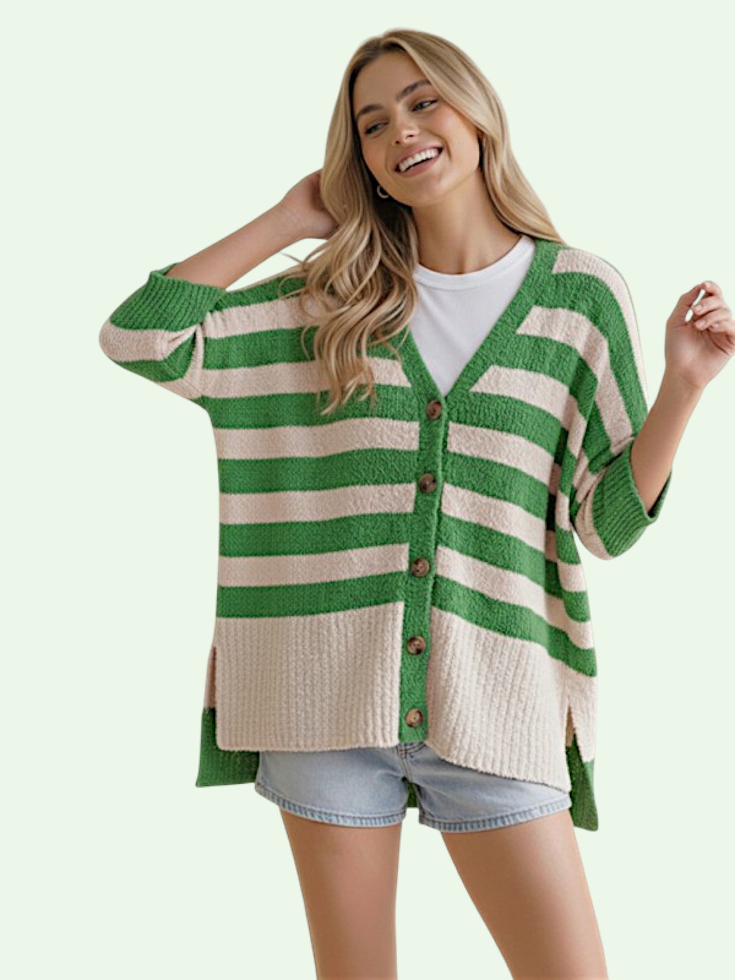 Woman wearing a green and white striped cardigan on a light green background