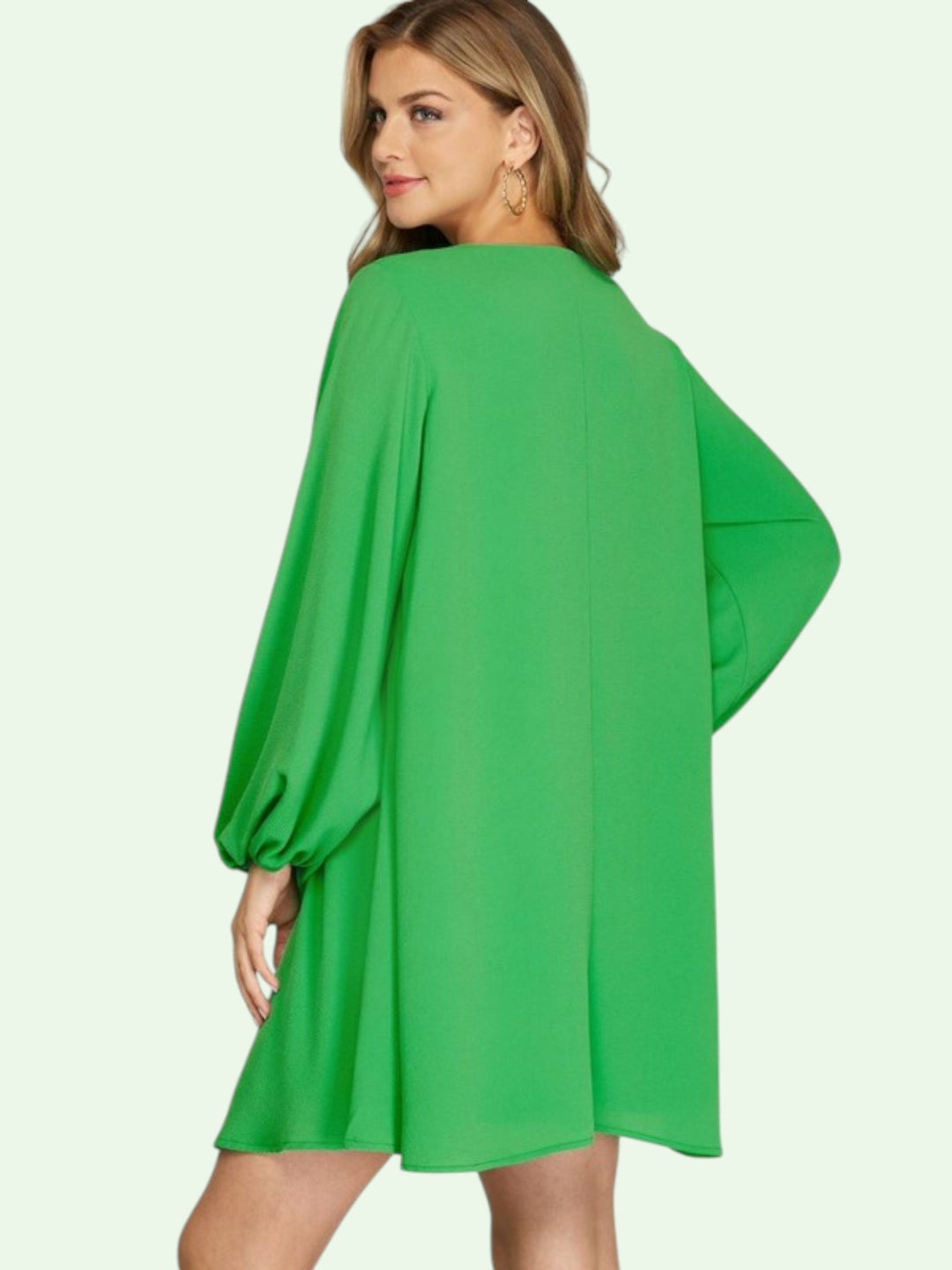 Green dress worn by a model on a white background