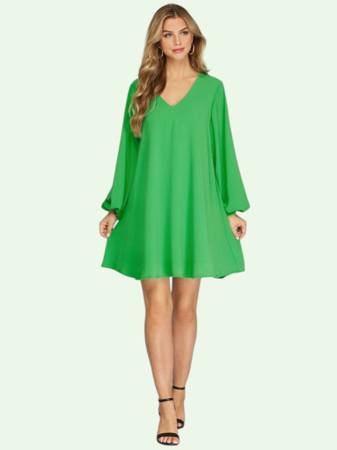 Woman wearing a green dress on a light green background