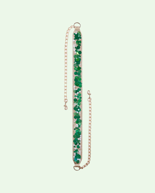 detachable bag strap with gold  chain ends and a strap of clear plastic full of shiny green confetti
