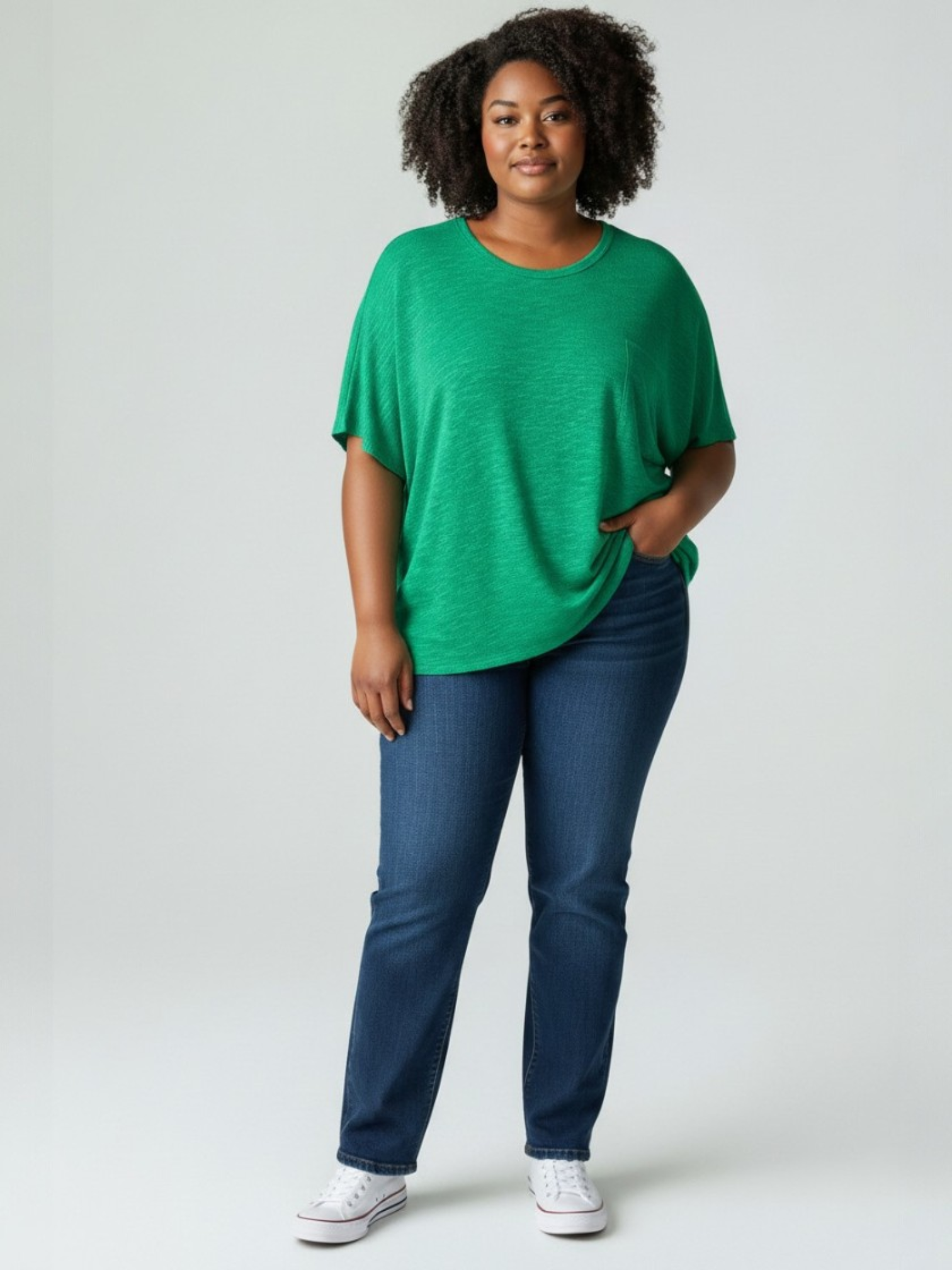 Woman wearing a green shirt and blue jeans on a white background