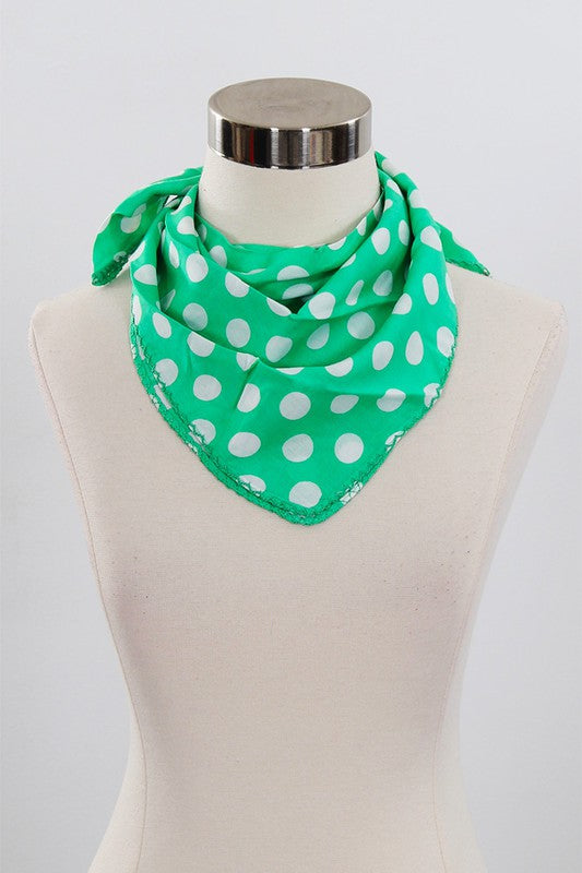 a polka dot green and white scarf tied all wild west around a mannequins neck