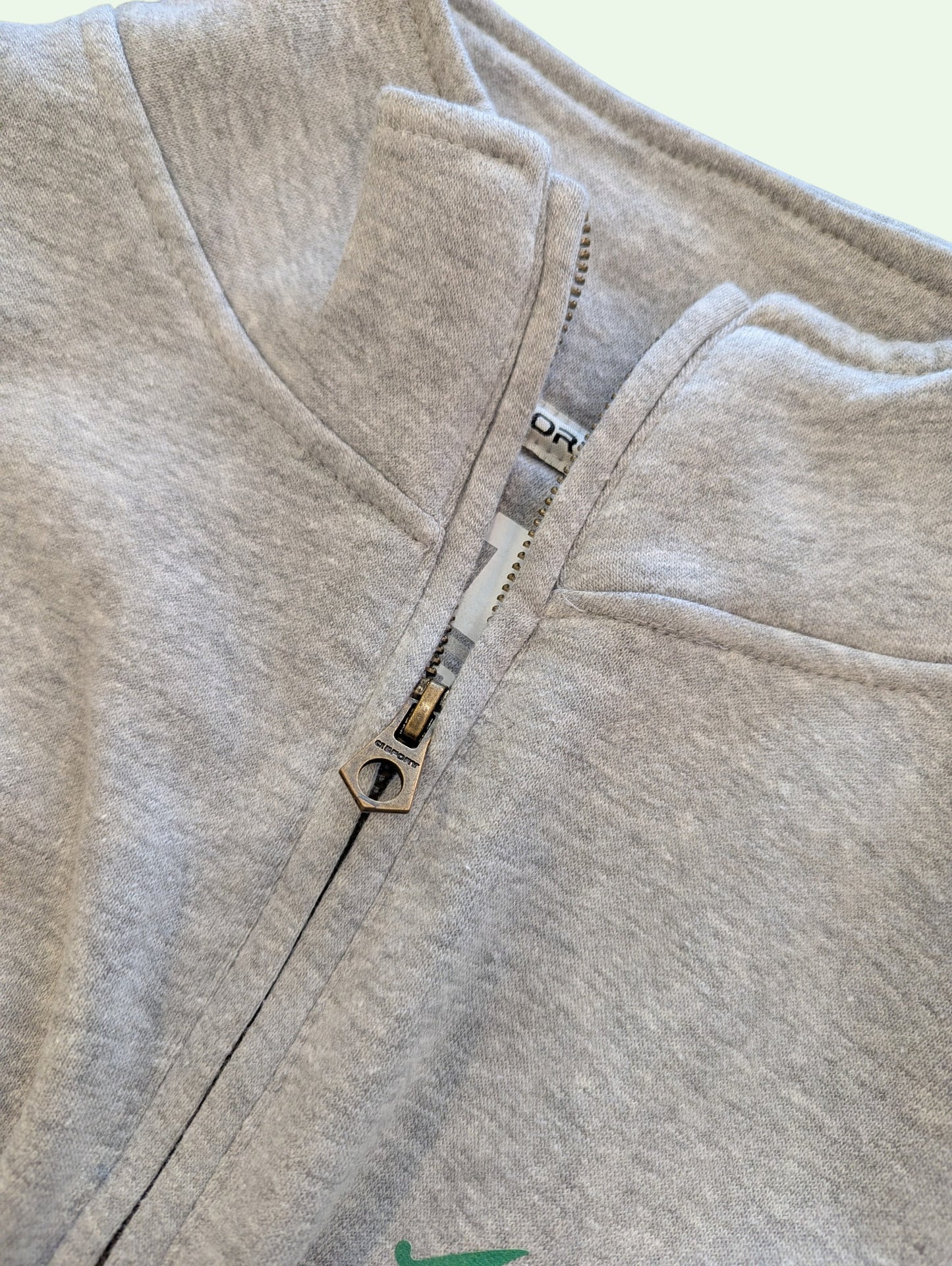 Close-up of a gray fleece jacket with a zipper on a white background