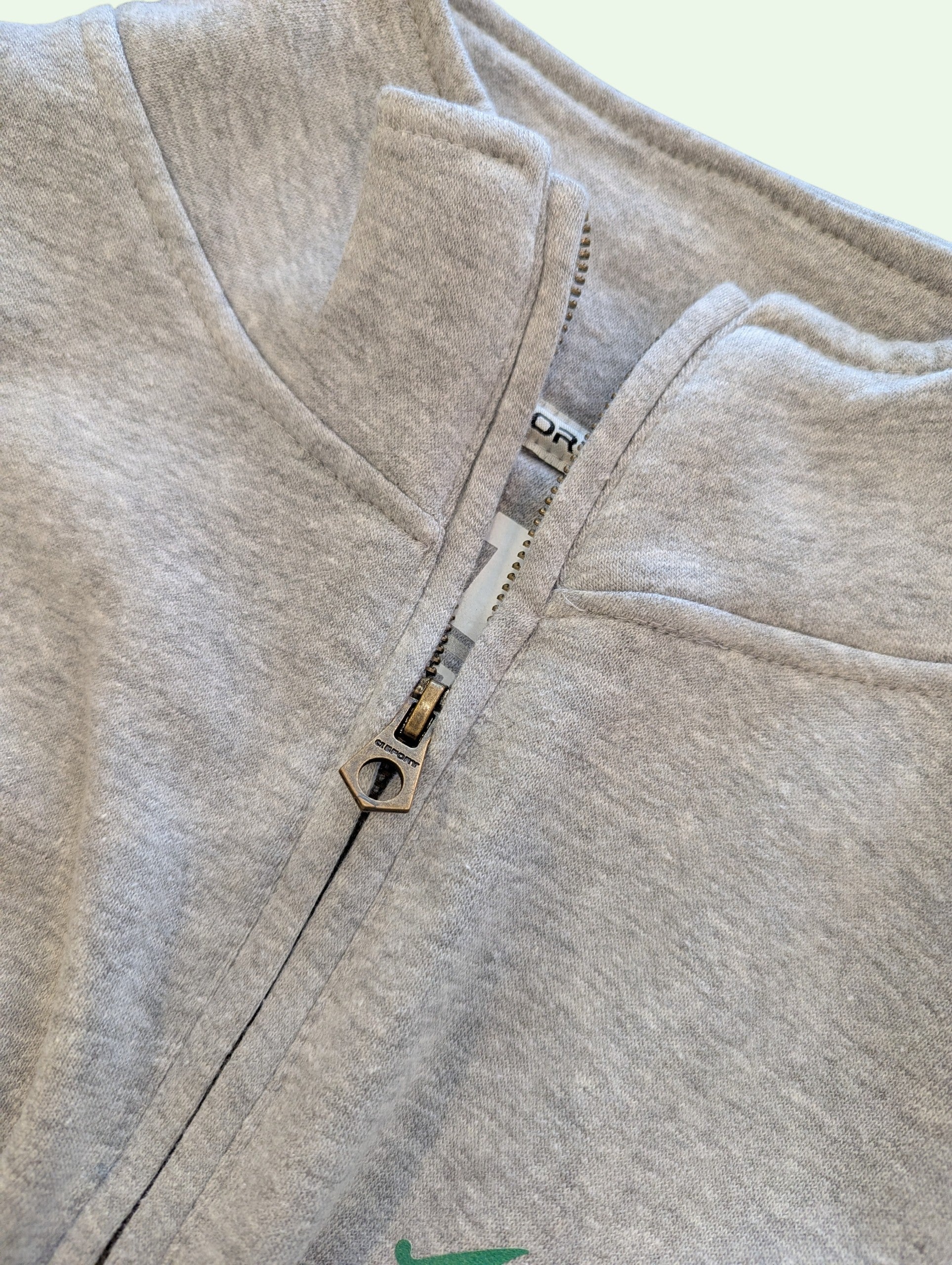 Close-up of a gray fleece jacket with a zipper on a white background