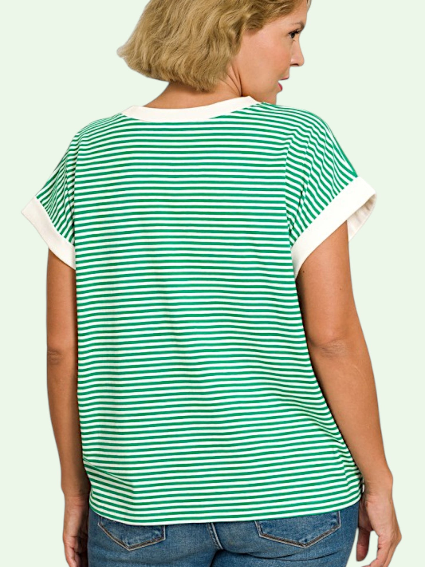 Woman wearing a green and white striped t-shirt showing us the back on a plain background