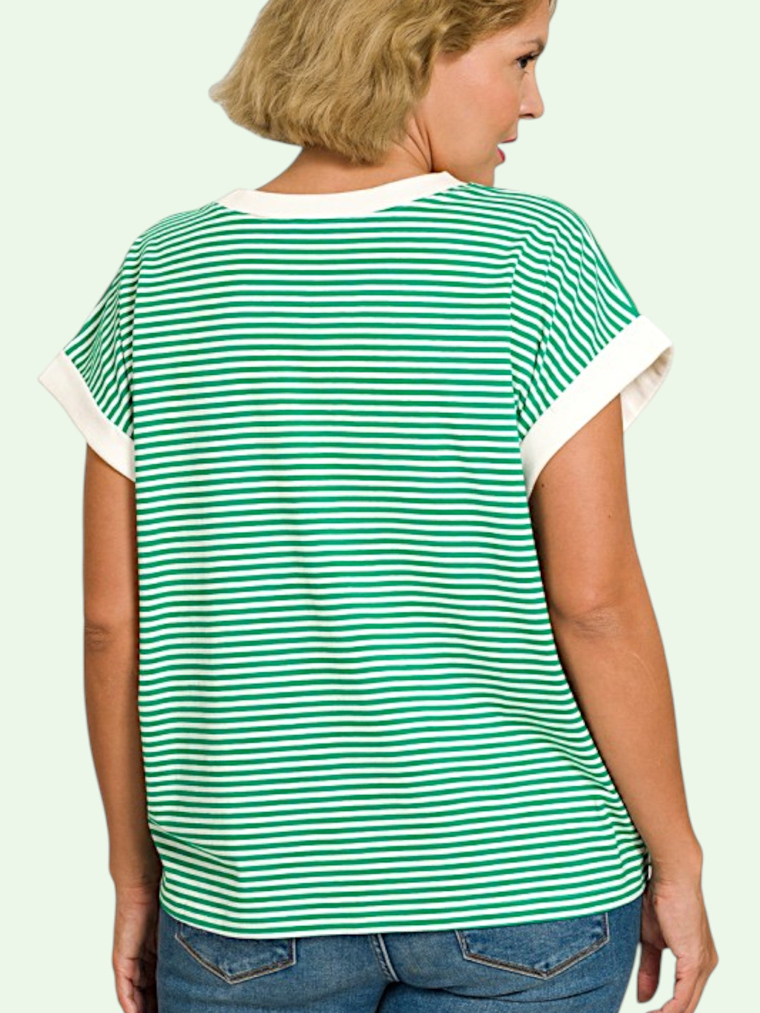 Woman wearing a green and white striped t-shirt showing us the back on a plain background