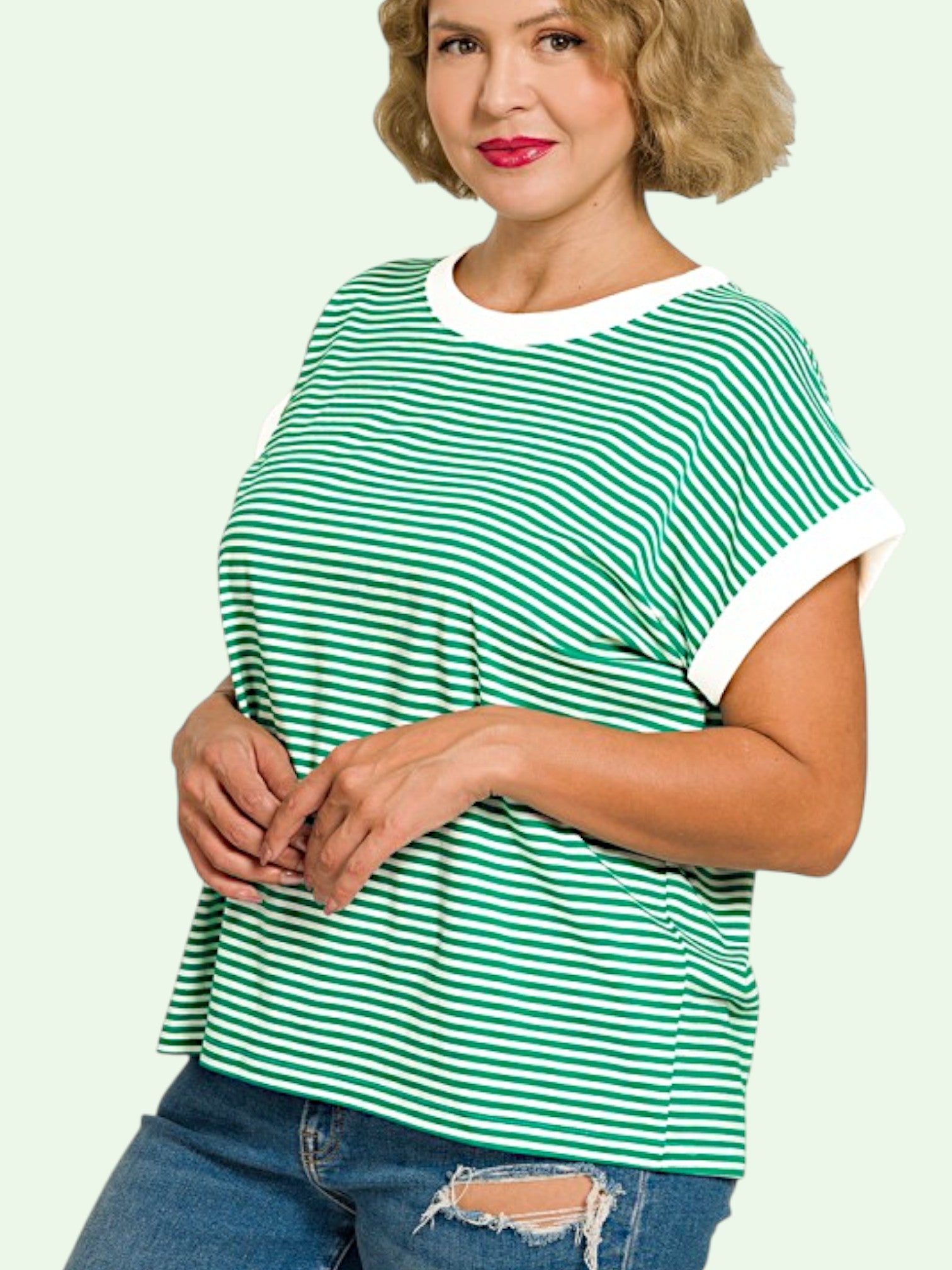 Woman wearing a green and white striped shirt on a light green background