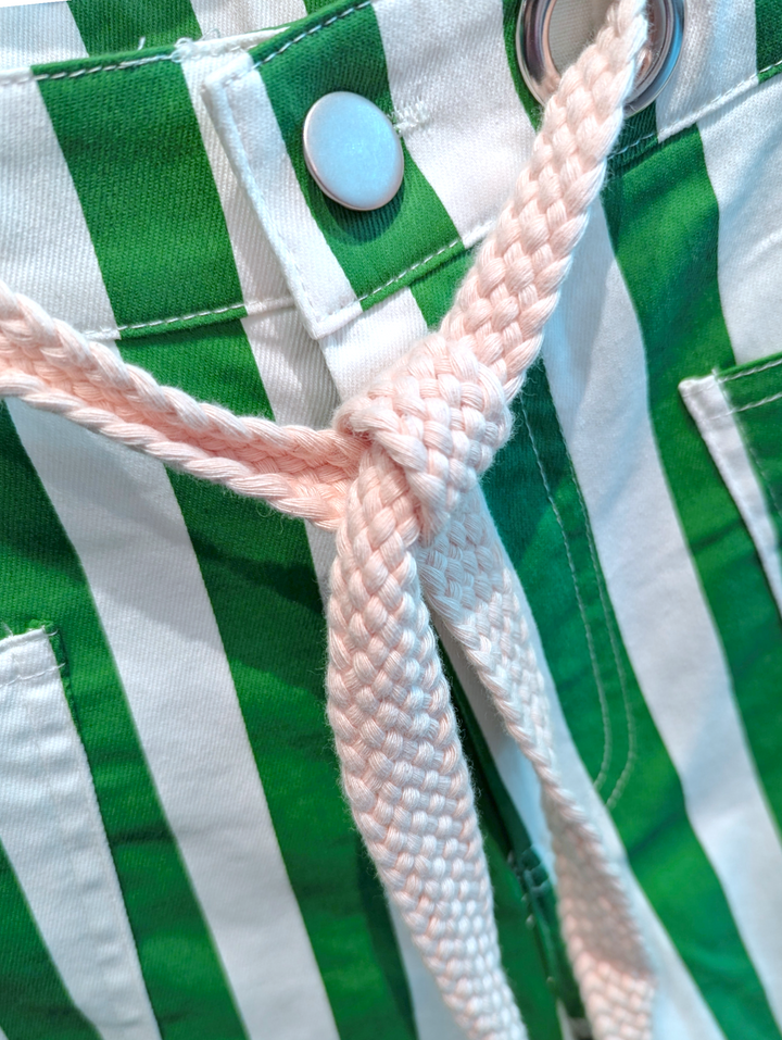 Close-up of green and white striped fabric with a button and woven cord.