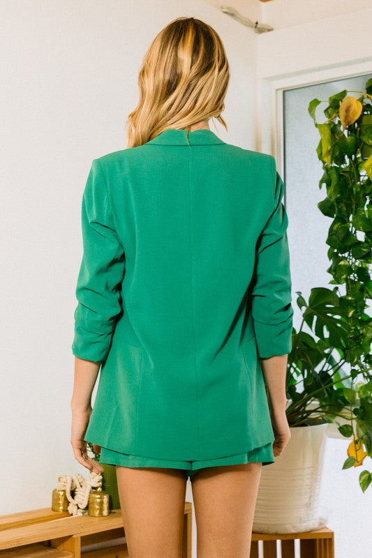 a model stands with her back to the camera in a kelly green blazer