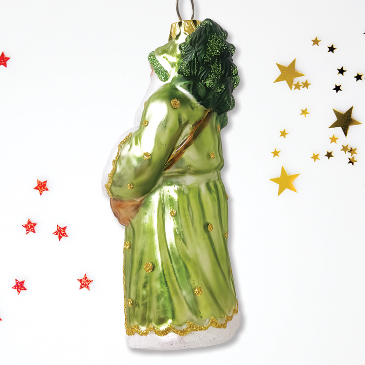 Decorative santa ornament  wearing a green robe, against a white background with decorative stars.