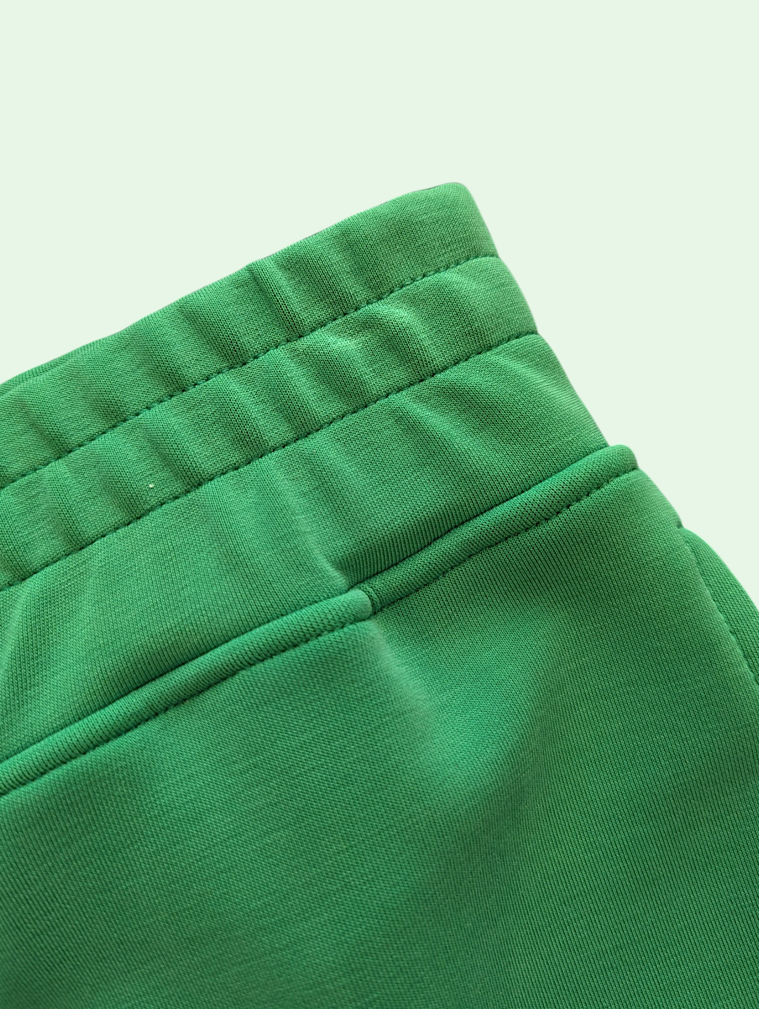 Close-up of green pants with a green 
background