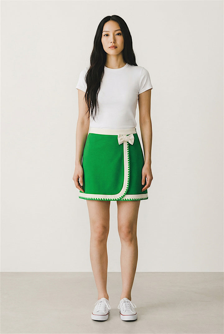 Woman wearing a white t-shirt and green skirt with a white background