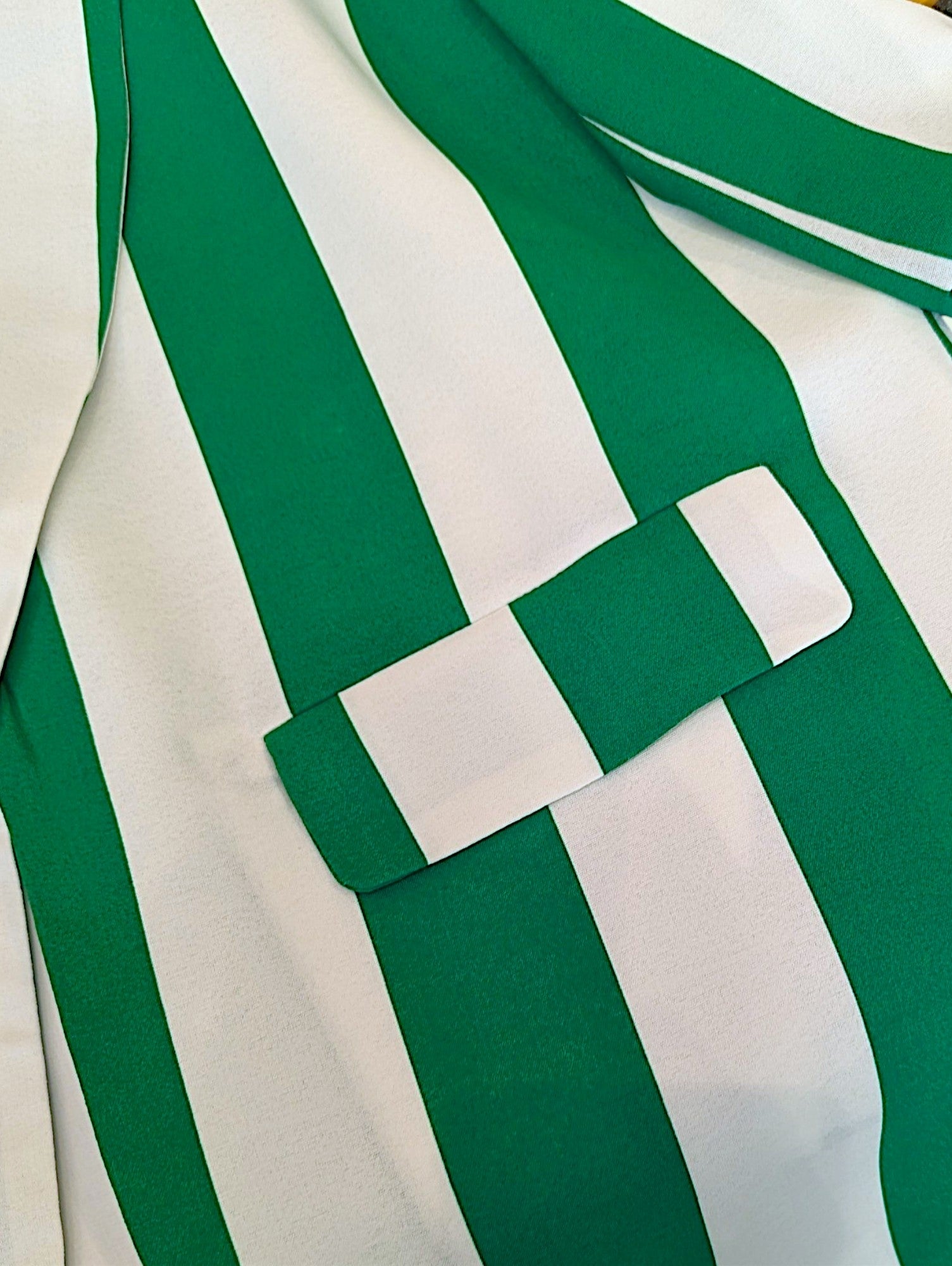 Close-up of a green and white vertically striped fabric garment with a matching fabric belt or tie detail crossing the front.