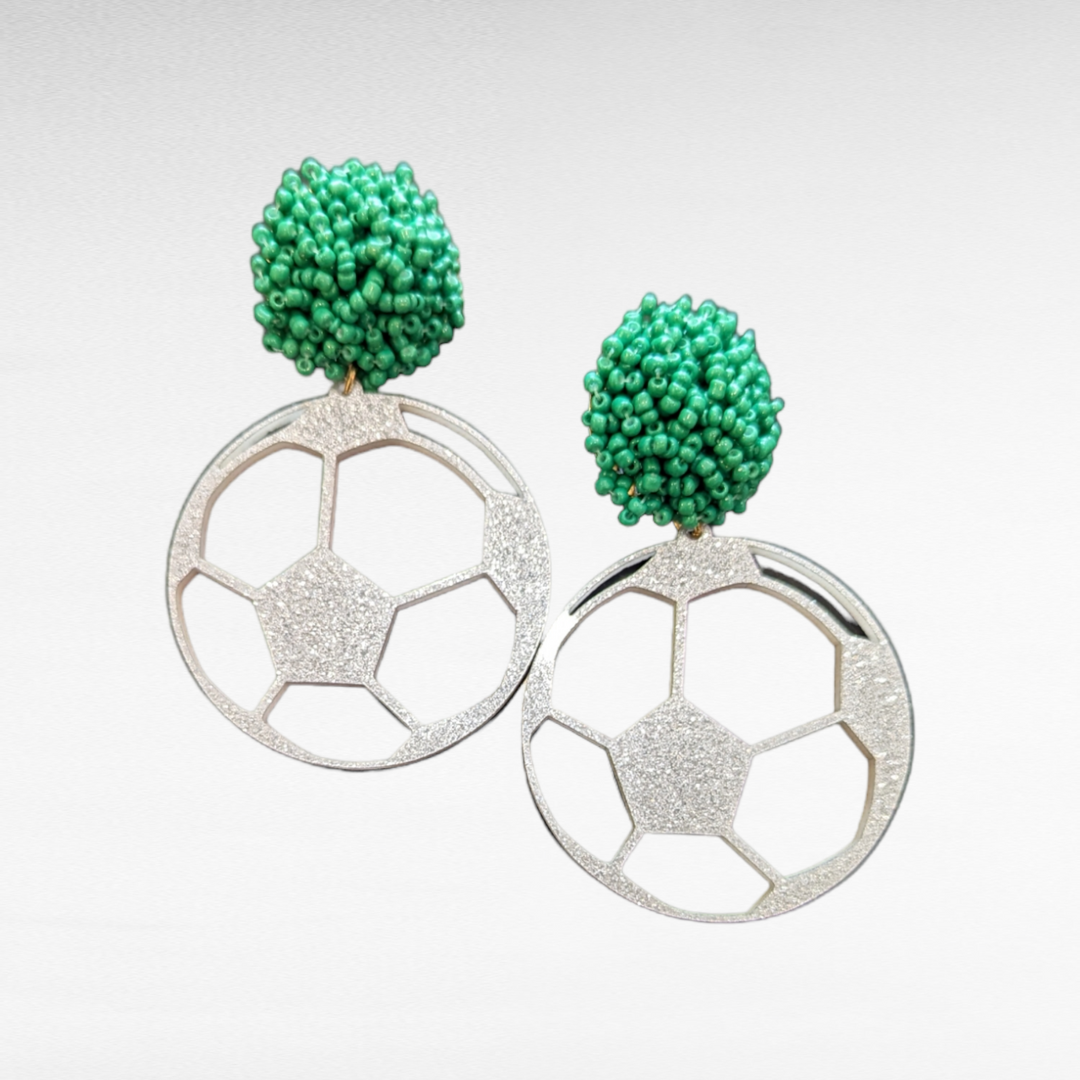 a studio shot of the soccer pom earrings
