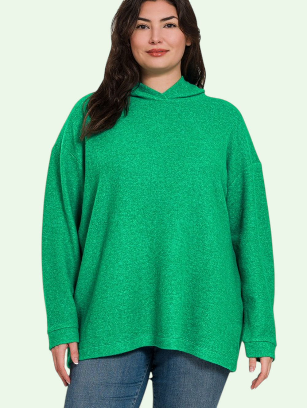 Woman wearing a green hoodie on a light background