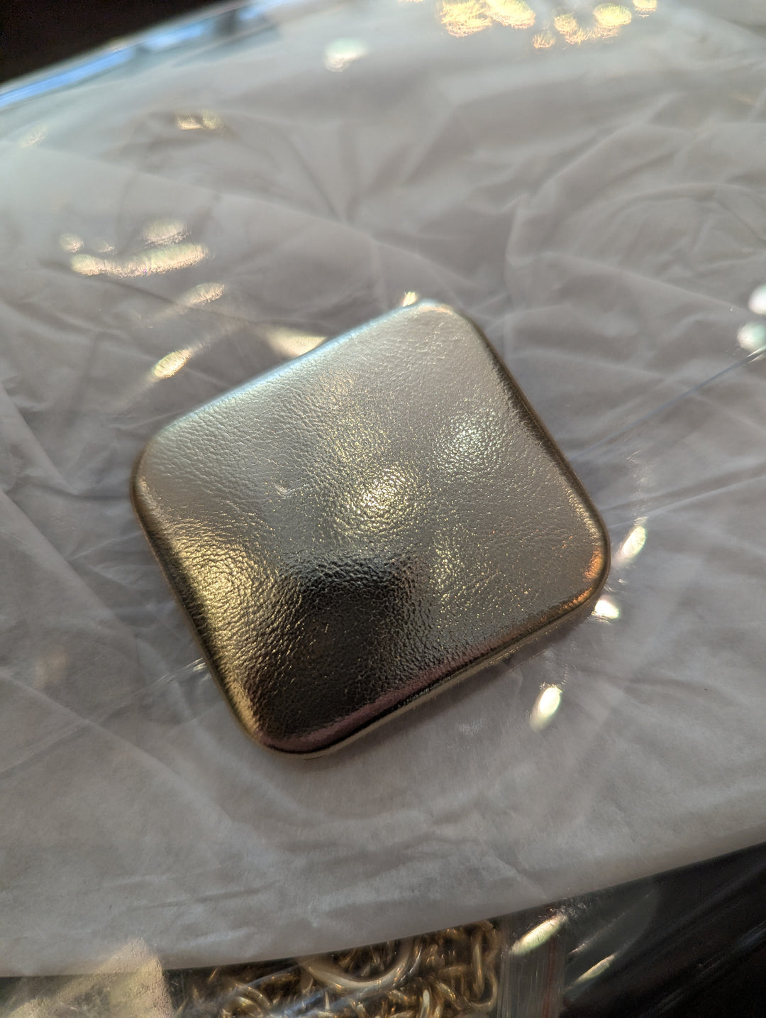 close up of the gold fastener on the stadium clutch